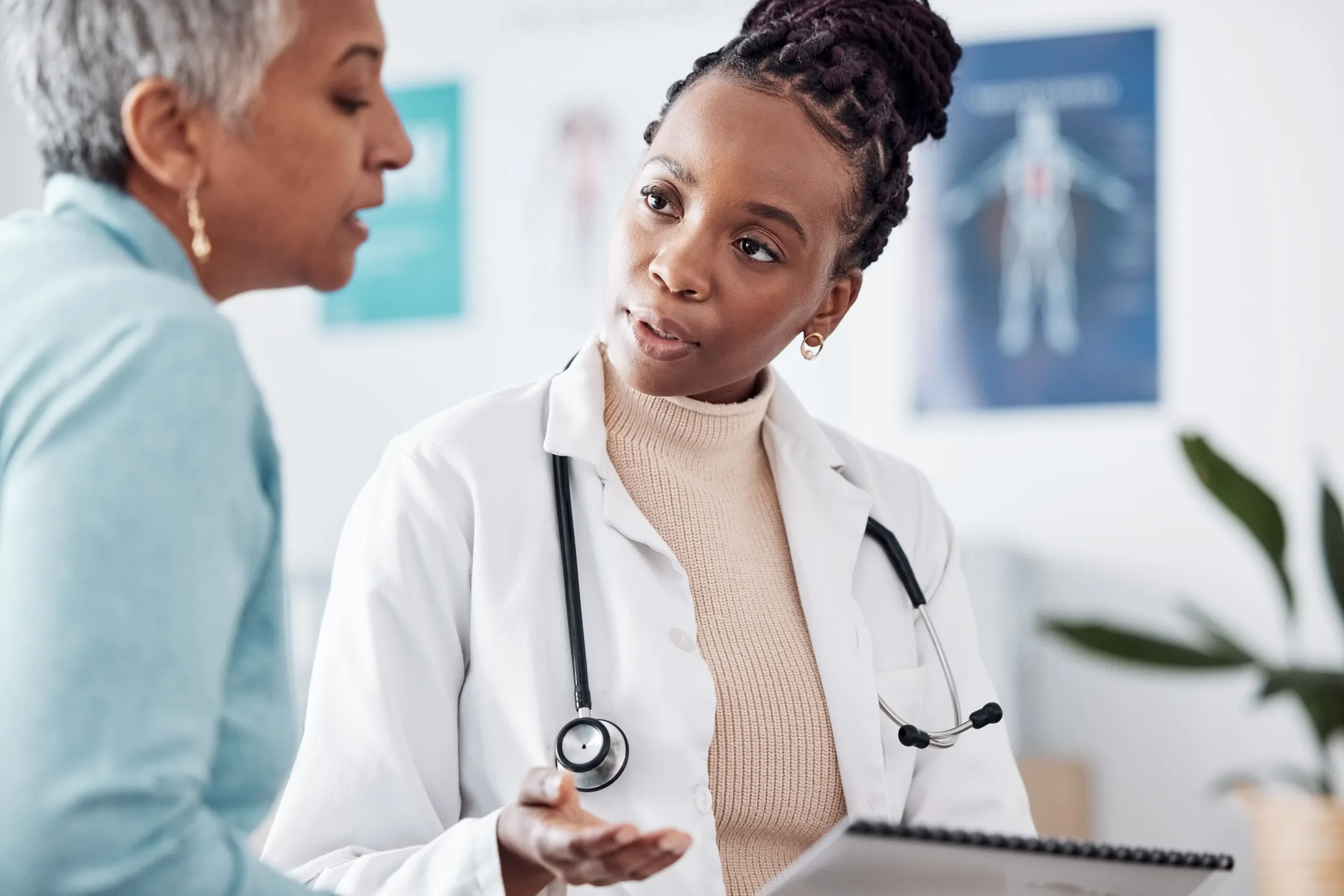 A physician listening to an older woman during a consultation.