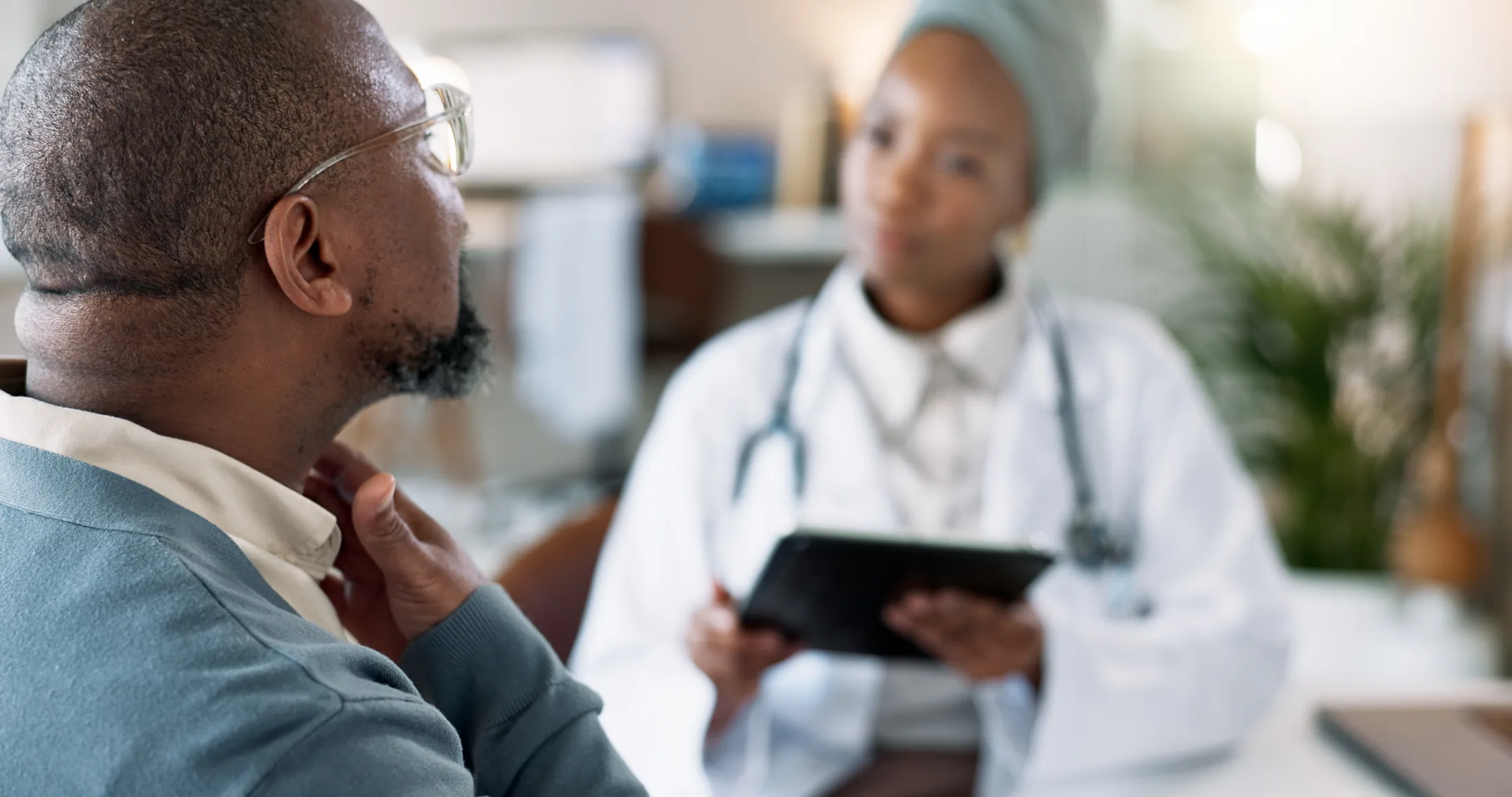 A man and a physician speaking together in a consultation room.